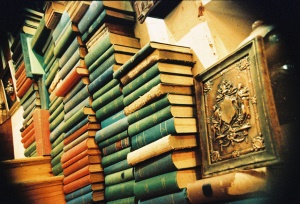 Image shows rows of antique-looking, dusty books.