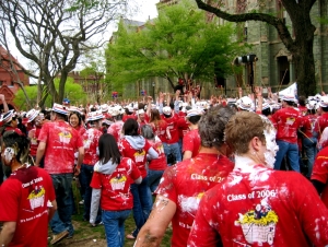 Image shows a group of students wearing matching red tee-shirts, some wearing silly hats and others partly covered in foam. 
